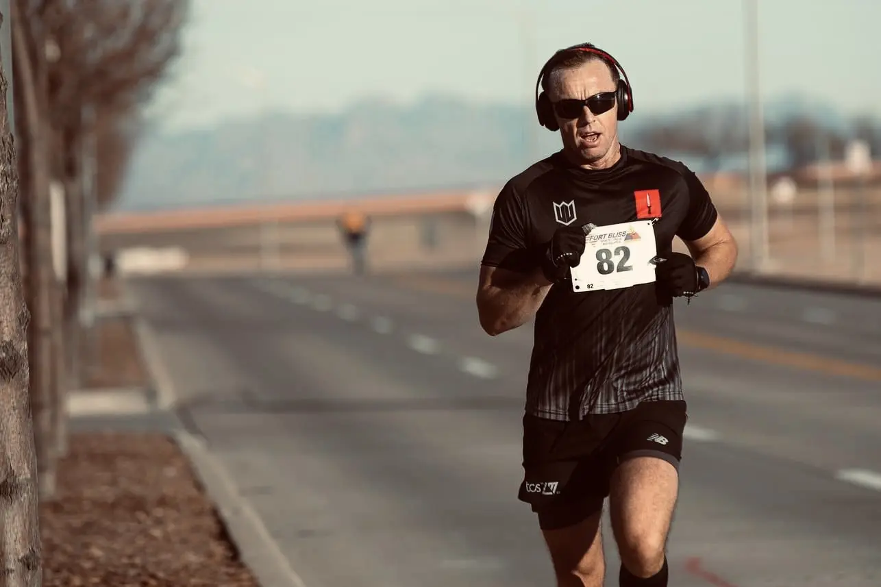Man wearing sunglasses runs in road race