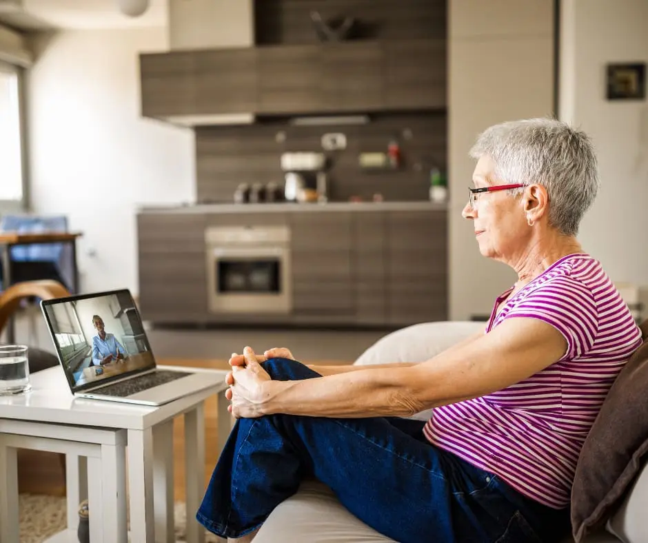 A woman in a virtual meeting on a laptop inside her home.